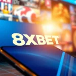 Engaging 8XBET online betting platform with dynamic visuals and a smartphone display.
